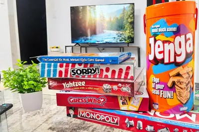 a stack of books with a television and a pile of snacks at Cozy 3BR Apt in Jersey City! near NYC & Metlife! in Jersey City