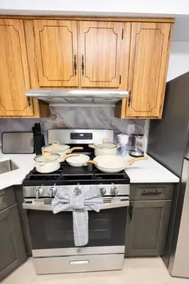 a kitchen with a stove with dishes on it at Cozy 3BR Apt in Jersey City! near NYC & Metlife! in Jersey City