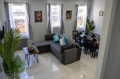 a living room with a couch and a table at 3BR duplex near MetLife! w/ Parking! mins to NY in Jersey City