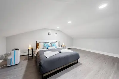 a large white bedroom with a large bed in it at 3BR duplex near MetLife! w/ Parking! mins to NY in Jersey City