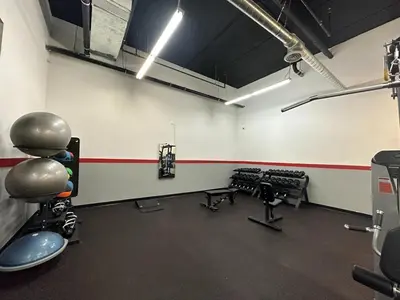 an empty room with a gym with weights at 4-Bedroom Furnished Apartment at Temple Crossing in Philadelphia