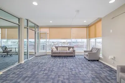 a living room with a couch and two chairs and windows at 4-Bedroom Furnished Apartment at Temple Crossing in Philadelphia