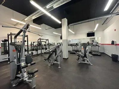 a gym with several treadmills and machines in it at 4-Bedroom Furnished Apartment at Temple Crossing in Philadelphia