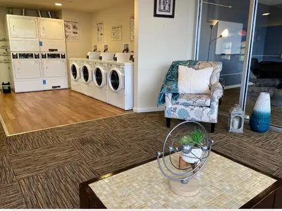a laundry room with a chair and washing machines at 4-Bedroom Furnished Apartment at Temple Crossing in Philadelphia