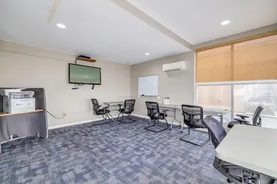 a conference room with chairs and a screen at 4-Bedroom Furnished Apartment at Temple Crossing in Philadelphia