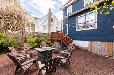 a patio with chairs and a table in front of a blue house at Jim Thorpe Center House - Families and Groups Welcome - Walkable in Jim Thorpe