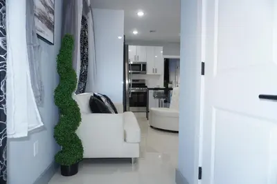 a living room with a white couch and a plant on the wall at Big Apple room 34 in West New York