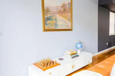 a living room with a chessboard on a white coffee table at Loft at Downtown Newark in Newark