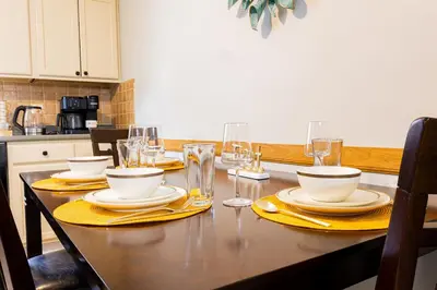 a dining room table with plates and glasses on it at Loft at Downtown Newark in Newark