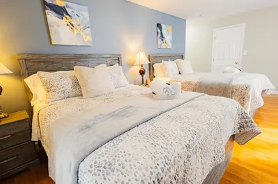 a bedroom with two beds with white comforters at Loft at Downtown Newark in Newark