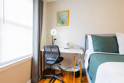 a bedroom with a desk and a bed and a chair at Loft at Downtown Newark in Newark