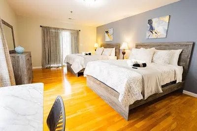 a bedroom with two beds and a wooden floor at Loft at Downtown Newark in Newark