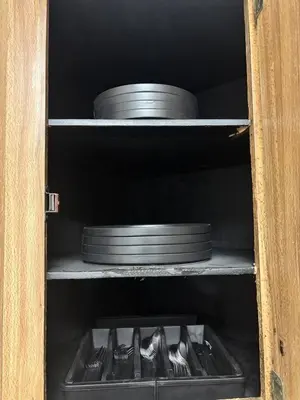 a cabinet with plates and utensils on a shelf at 3BR home in Jersey city ! near metlife & NYC train in Jersey City
