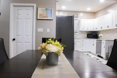 a kitchen with a table with a vase of flowers on it at Elegant 3BR Stay | Mins to NYC • Near Dream Mall in Newark