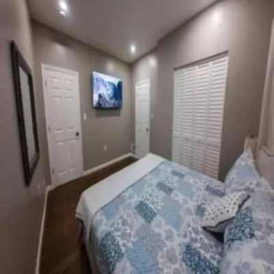 a bedroom with a bed and a tv on the wall at Elegant 3BR Stay | Mins to NYC • Near Dream Mall in Newark