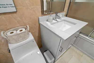 a bathroom with a white sink and a toilet at Cozy Retreat 15Min to NYC, FIFA, Mall,FREE Parking - Apartment in North Bergen