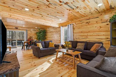a living room with wooden walls and a wooden ceiling at Log Cabin Game Room Close to the Slopes & Lake in Albrightsville