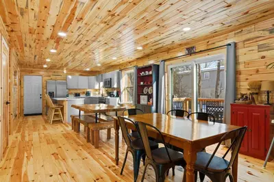 a kitchen with wooden ceilings and tables and chairs at Log Cabin Game Room Close to the Slopes & Lake in Albrightsville