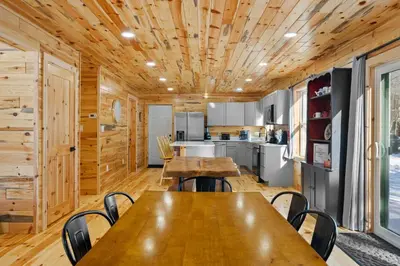 a kitchen with wooden ceilings and wooden tables and chairs at Log Cabin Game Room Close to the Slopes & Lake in Albrightsville