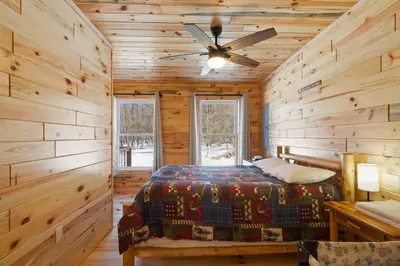 a bedroom with a bed and a ceiling fan at Log Cabin Game Room Close to the Slopes & Lake in Albrightsville