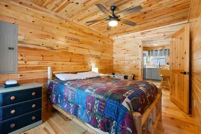 a bedroom with a bed and a ceiling fan at Log Cabin Game Room Close to the Slopes & Lake in Albrightsville