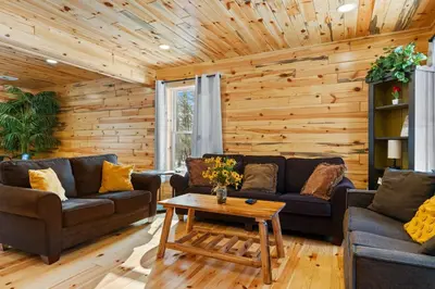 a living room with couches and a coffee table at Log Cabin Game Room Close to the Slopes & Lake in Albrightsville