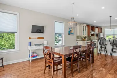 a kitchen and dining room with a wooden table and chairs at Lakefront Game Room Hot Tub Close to it All in Lake Harmony