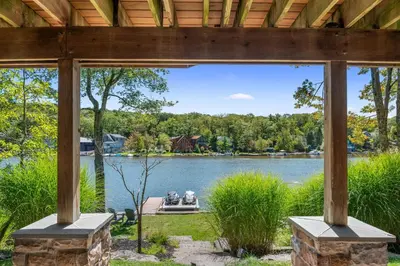 a screened in porch with a view of a lake at Lakefront Game Room Hot Tub Close to it All in Lake Harmony