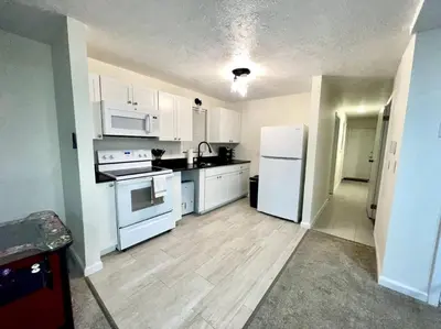 a kitchen with white cabinets and a white refrigerator at Spacious New4BR 3BA 2kit GameRm Firepit Amenity in Tobyhanna