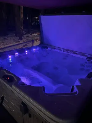 a jacuzzi tub with purple lights in the dark at Inn Harmony- Cabin with Game Room Hot Tub Firepit in Lake Harmony