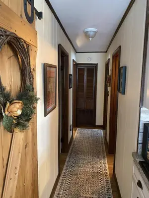 a hallway with a wooden door and a rug at Inn Harmony- Cabin with Game Room Hot Tub Firepit in Lake Harmony