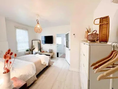 a white bedroom with a bed and a living room at Home for 8, Parking & Patio in Phoenixville