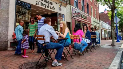 a group of people sitting at tables on a street at Relaxing Stay Sleeps 4 & 2 Parking in Phoenixville