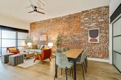 a living room with a brick wall and a table and chairs at Cozy & Historic Old City 2 Bedroom - Sleeps 5 in Philadelphia