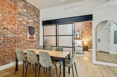 a dining room with a brick wall and a table and chairs at Cozy & Historic Old City 2 Bedroom - Sleeps 5 in Philadelphia