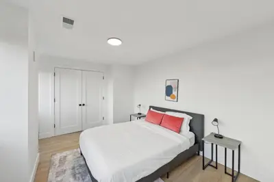 a bedroom with a white bed with a red pillow at Market View Residence stunning 1bd Apt in Wilmington