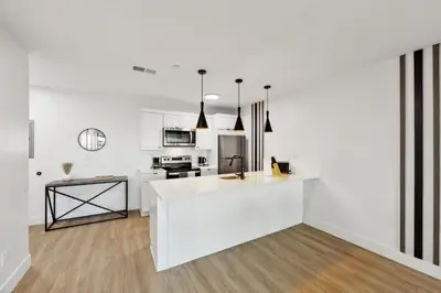 a white kitchen with a white island in a room at Market View Residence stunning 1bd Apt in Wilmington