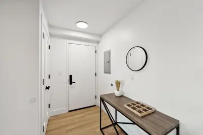 a hallway with a table and a mirror on a wall at Market View Residence stunning 1bd Apt in Wilmington