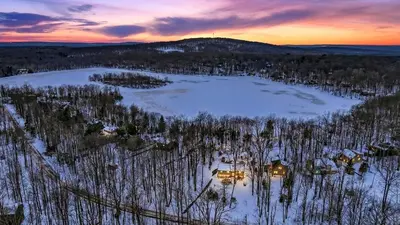 an aerial view of a house in the woods in the snow at Evergreen Lodge by AvantStay Poconos Lake Cabin Fireplace Large Deck Near Jack Frost Kalahari in Locust Lakes Village