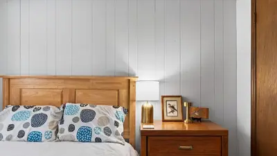 a bedroom with a bed and a nightstand with a lamp at Evergreen Lodge by AvantStay Poconos Lake Cabin Fireplace Large Deck Near Jack Frost Kalahari in Locust Lakes Village