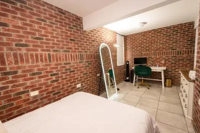 a brick walled bedroom with a bed and a desk at Luxurious 4BD APT EV Parking in North Bergen