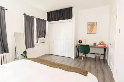 a bedroom with a bed and a desk and a table at Luxury North Bergen 3 BR APT in North Bergen