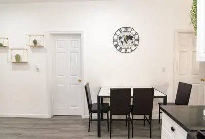 a dining room with a table and chairs and a clock at Luxury North Bergen 3 BR APT in North Bergen