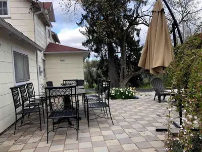 a patio with a table and an umbrella and chairs at 20 min Woodbury Outlet & USMA 35 min Mt Creek in Chester