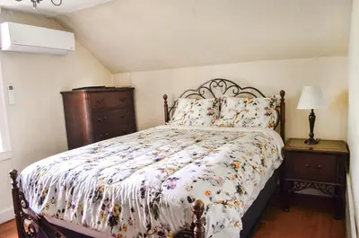 a bedroom with a bed with a floral comforter at 20 min Woodbury Outlet & USMA 35 min Mt Creek in Chester