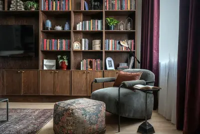 a living room with a chair and a book shelf at Cozy Artisan Loft with Literary Charm - Book Binder in Philadelphia