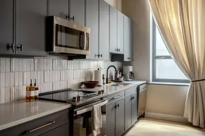 a kitchen with white cabinets and a sink and a microwave at Stunning Artisan Loft Chic & Modern - The Botanist in Philadelphia