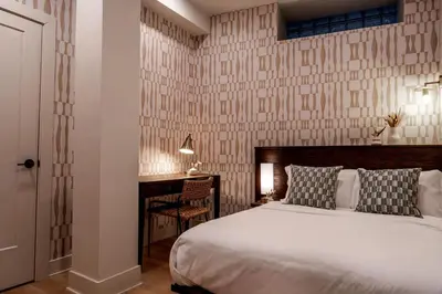a bedroom with a white bed and a desk with a desk at Elegant Artisan Loft W Private Parking - The Weaver in Philadelphia