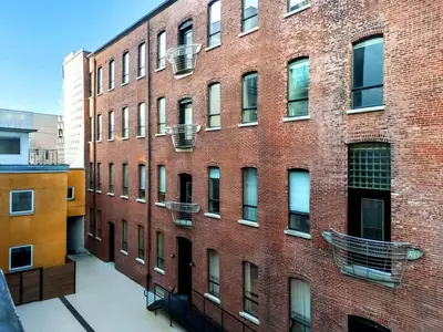 a large red brick building with balconies on it at Elegant Artisan Loft W Private Parking - The Weaver in Philadelphia
