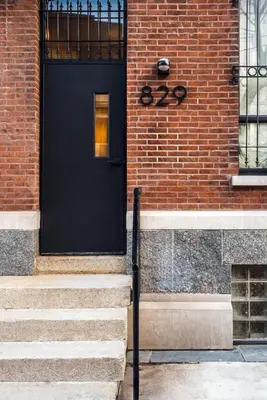 a black door on the side of a brick building at Exquisite Artisan Loft w Chic Design - The Cobbler in Philadelphia